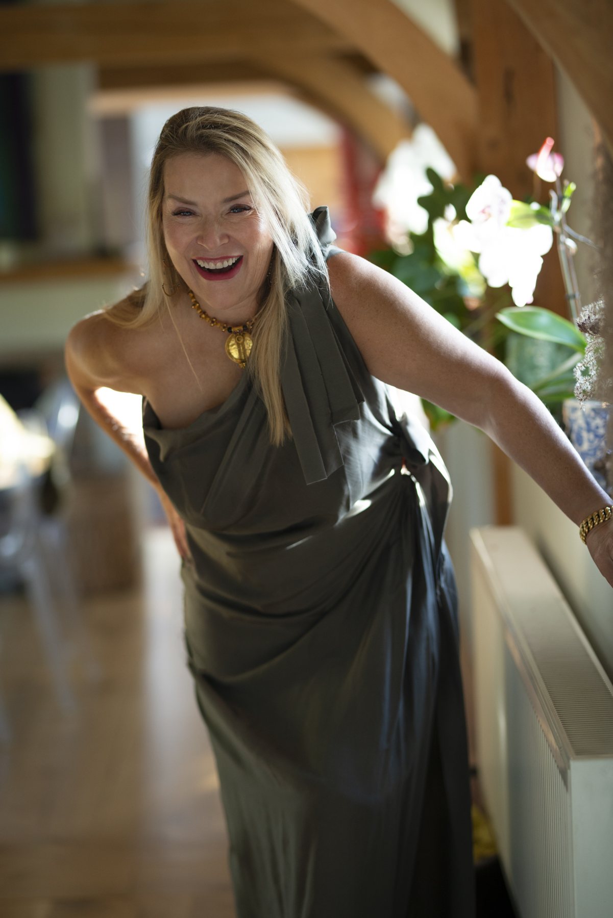 Juliette laughing as she steps forward in a long grey dress