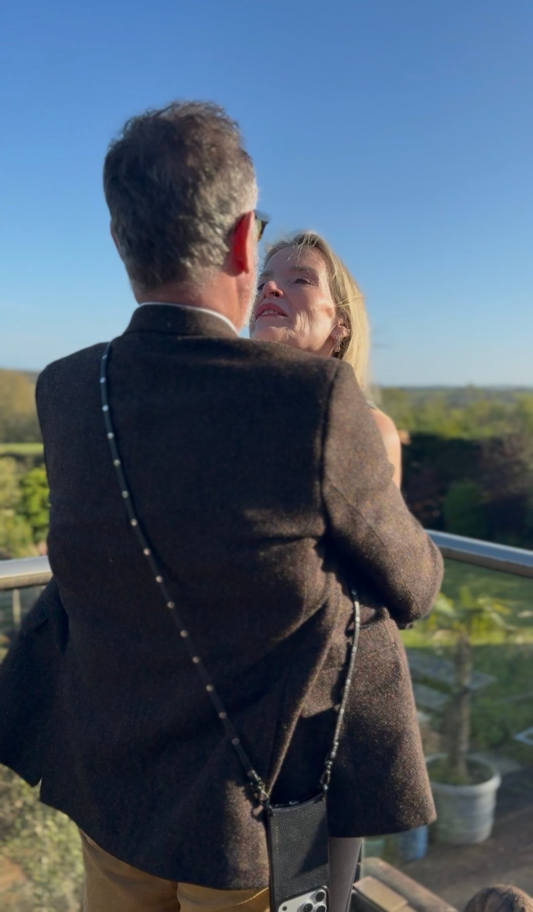 Alex holding Juliette on a balcony in the sun