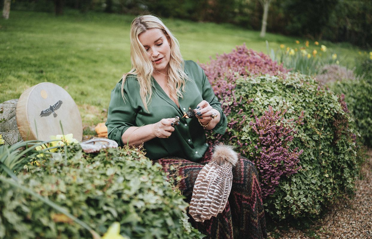 Juliette in a garden, kneeling among flowers in a green shirt