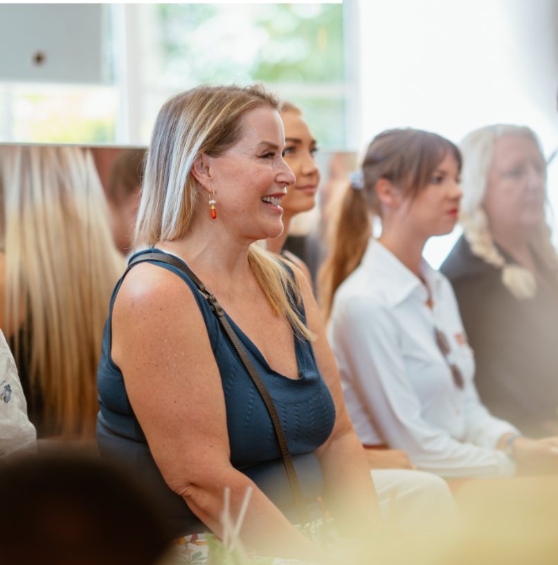 Juliette smiling among women at a live event